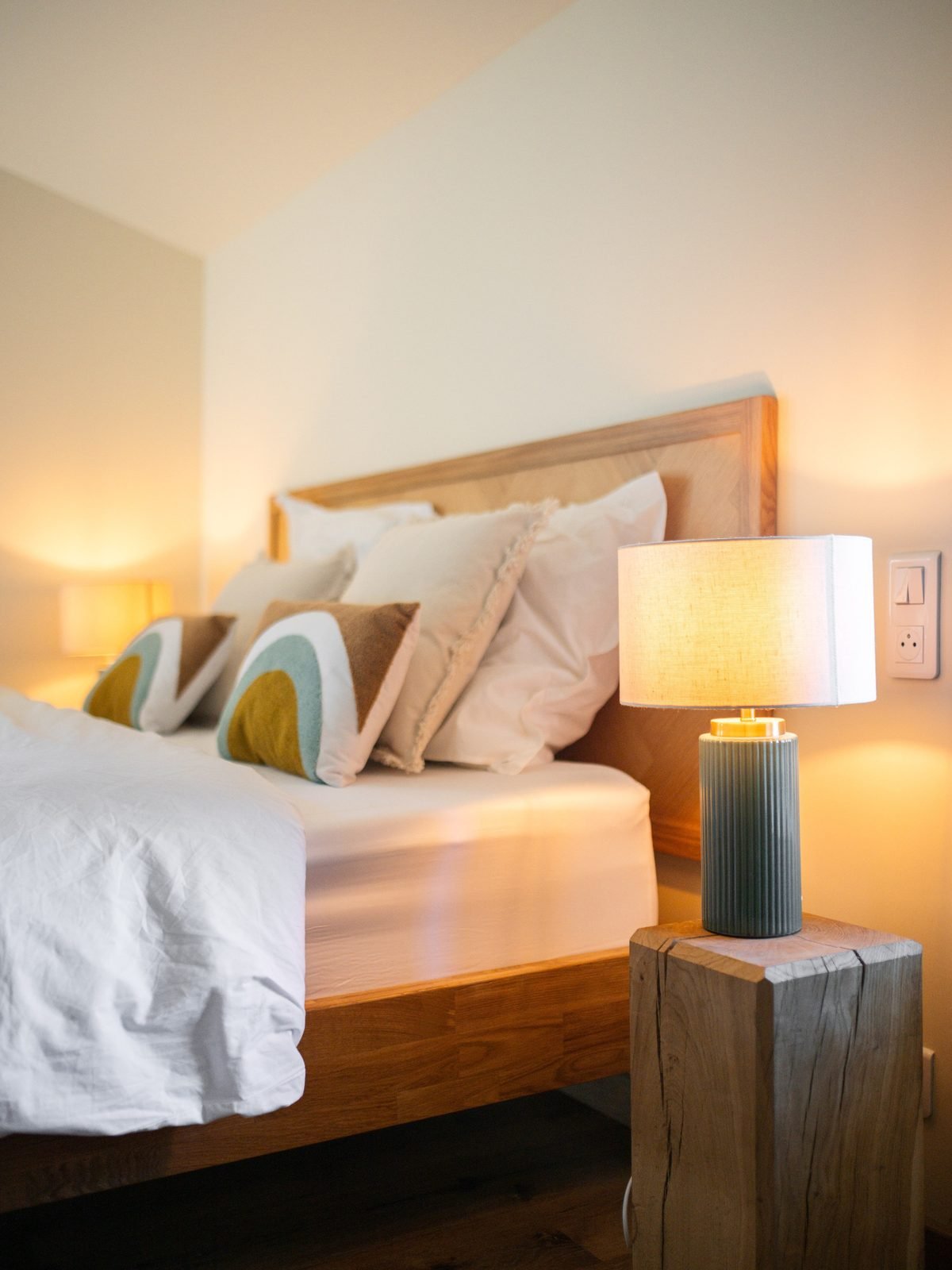 Une chambre de l'auberge : lit, bois clair, lumière douce